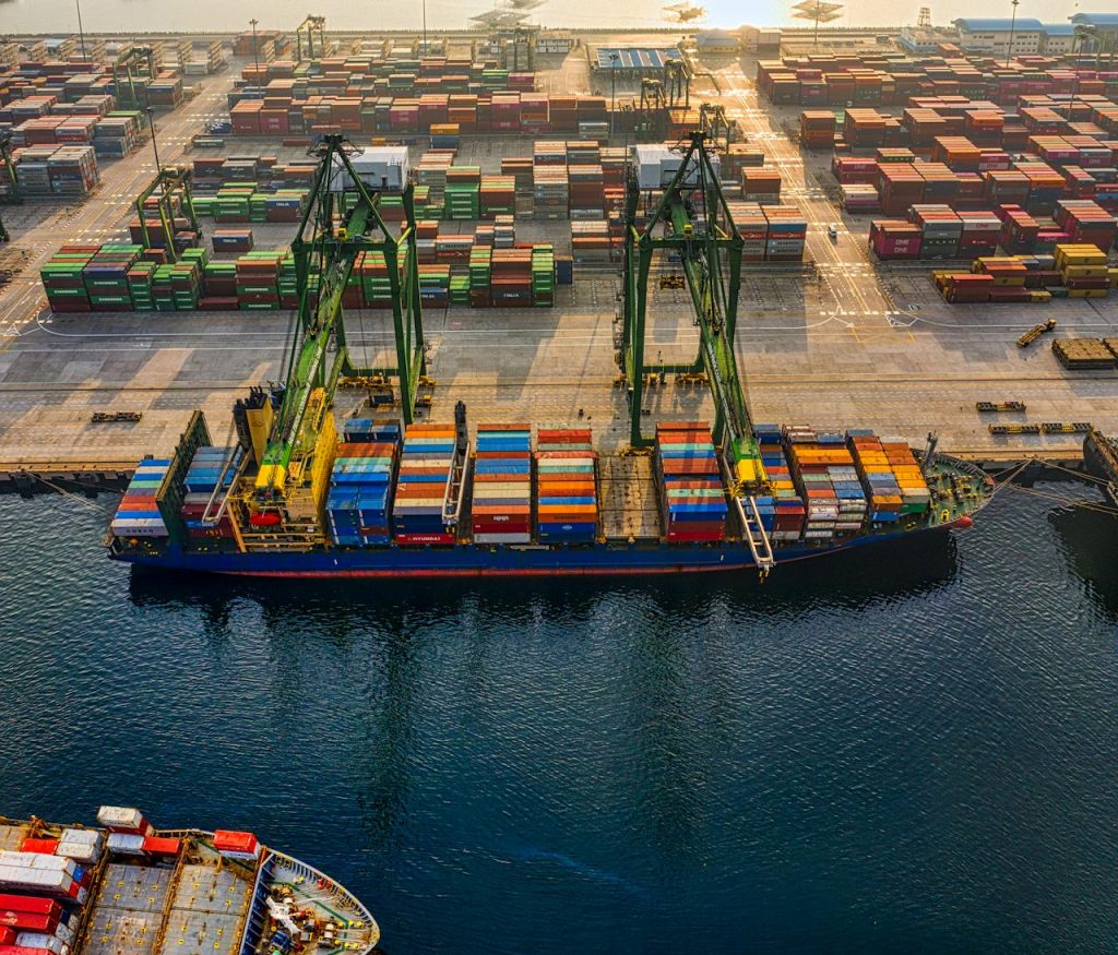drone-shot-of-a-cargo-ship-on-port-3856433 Aerial shot of colorful shipping containers at North Jakartas bustling port, Indonesia.